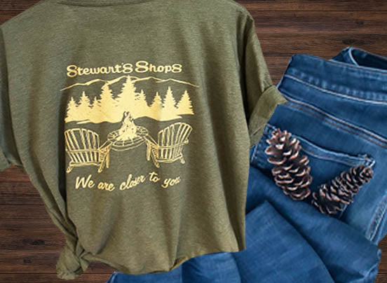 Stewarts Shops, We are closer to you green t-shirt with an Adirondack scene. Pair of jeans folded next to it.