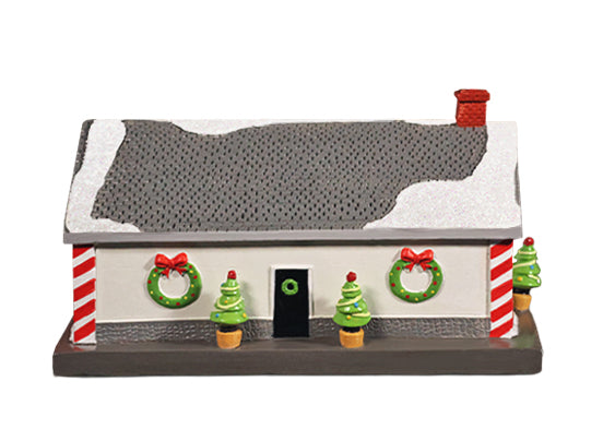 Small model of a house with Christmas decorations on a white background