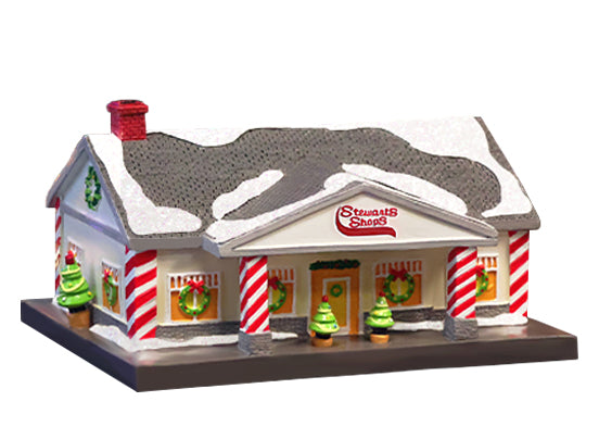 Model of a snowy building with striped columns and Christmas trees in front, on a white background.