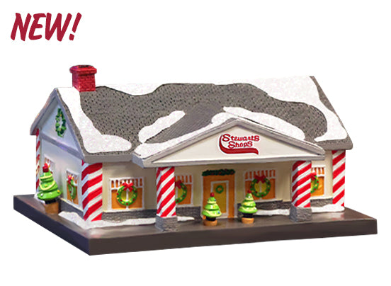 Model of a building with 'Stewarts Shops' sign, decorated for Christmas, on a white background.