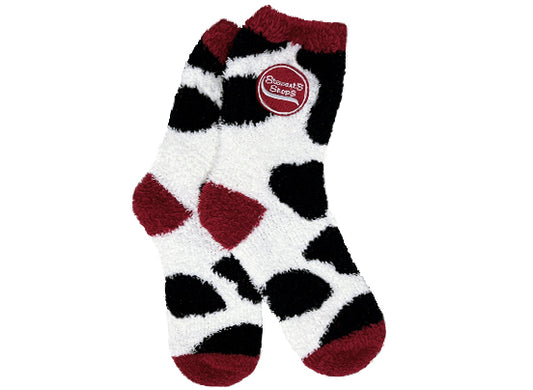Fuzzy socks with cow print and the Stewart's Shops logo. The top, heal, and toes are maroon. 