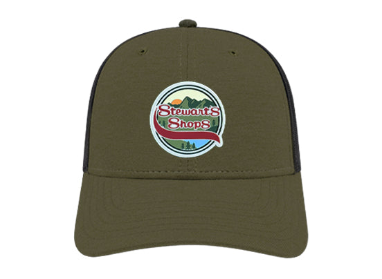 Olive green Stewart’s Shops trucker-style hat with a black mesh back. The front features a round patch design showing mountains, a sunset, and pine trees with the Stewart’s Shops logo in red and white.