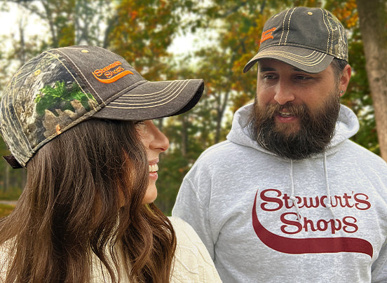 man and woman wearing Hat with Realtree Camouflage and an orange Stewarts Shops logo