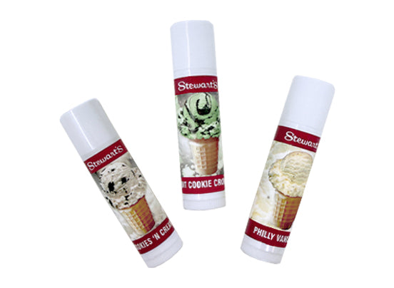 Three upright Stewart’s Shops ice cream lip balm tubes with cone-style designs labeled Cookies ’n Cream, Cookie Crumbs, and Philly Vanilla.